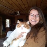 Libby McCaskey, SUDP, smiling and holding a large cat