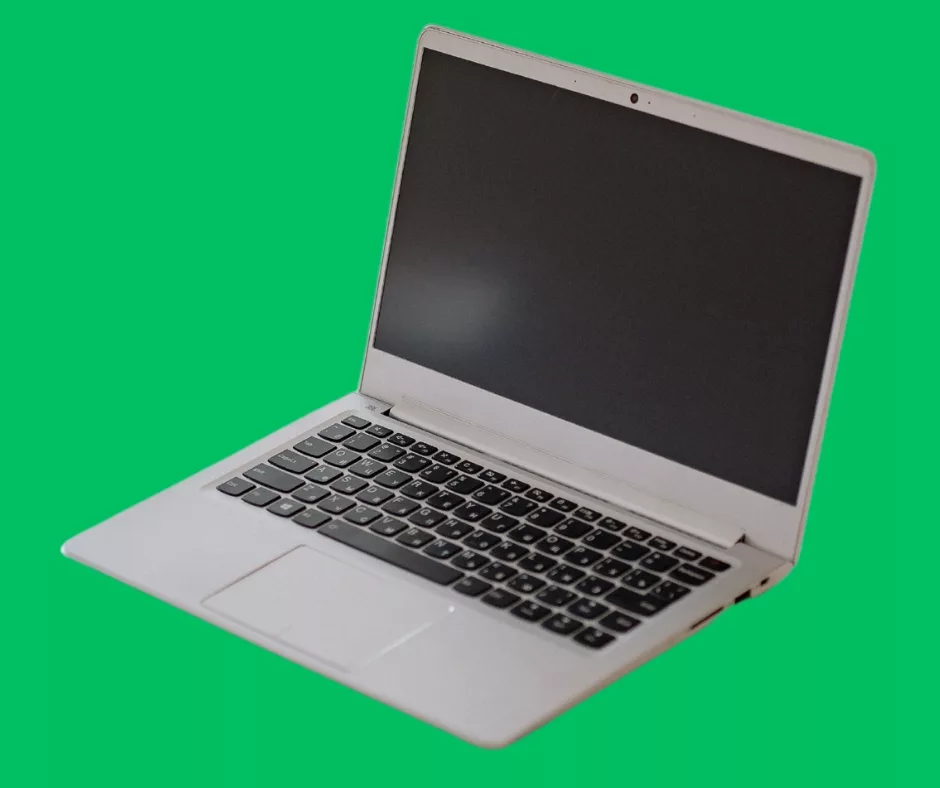 gray laptop with blank screen sits on green background