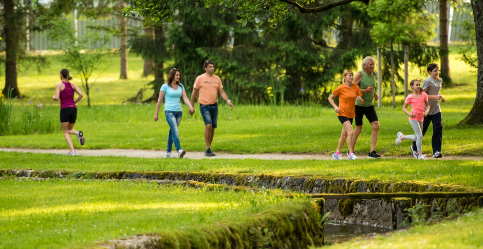 Image of people walking and running along a trail through a park