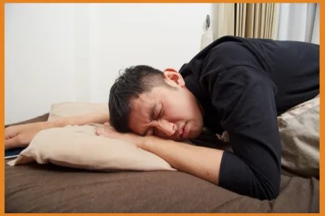 Man experiencing hangover winces in pain